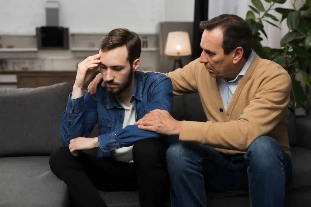 A father comforting his adult son, showing the importance of support in bipolar care.
